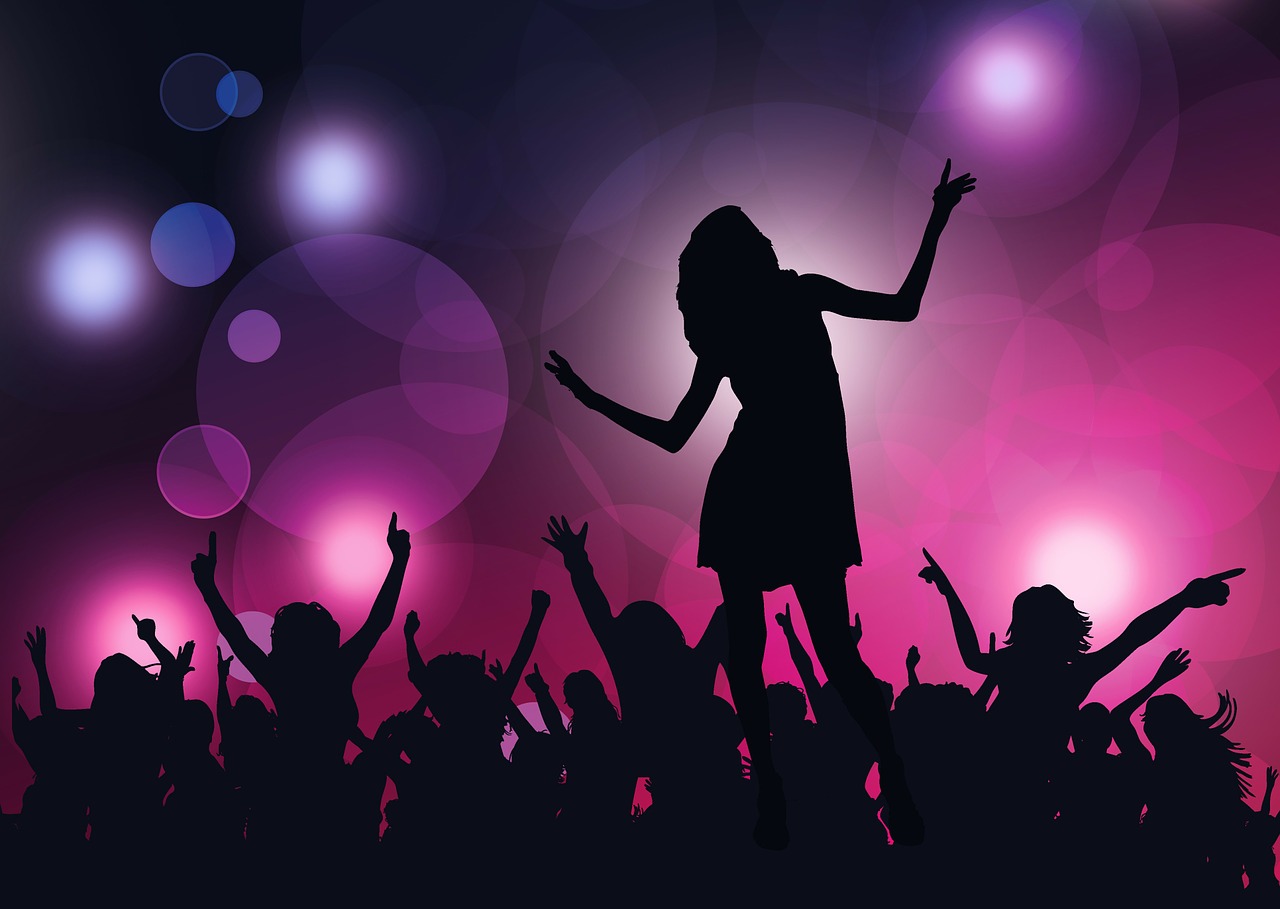 Silhouettes of people dancing under club lighting